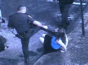 Police abuse, cop kicks woman in the head.